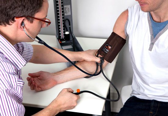 кардиолог измеряет пациенту давление